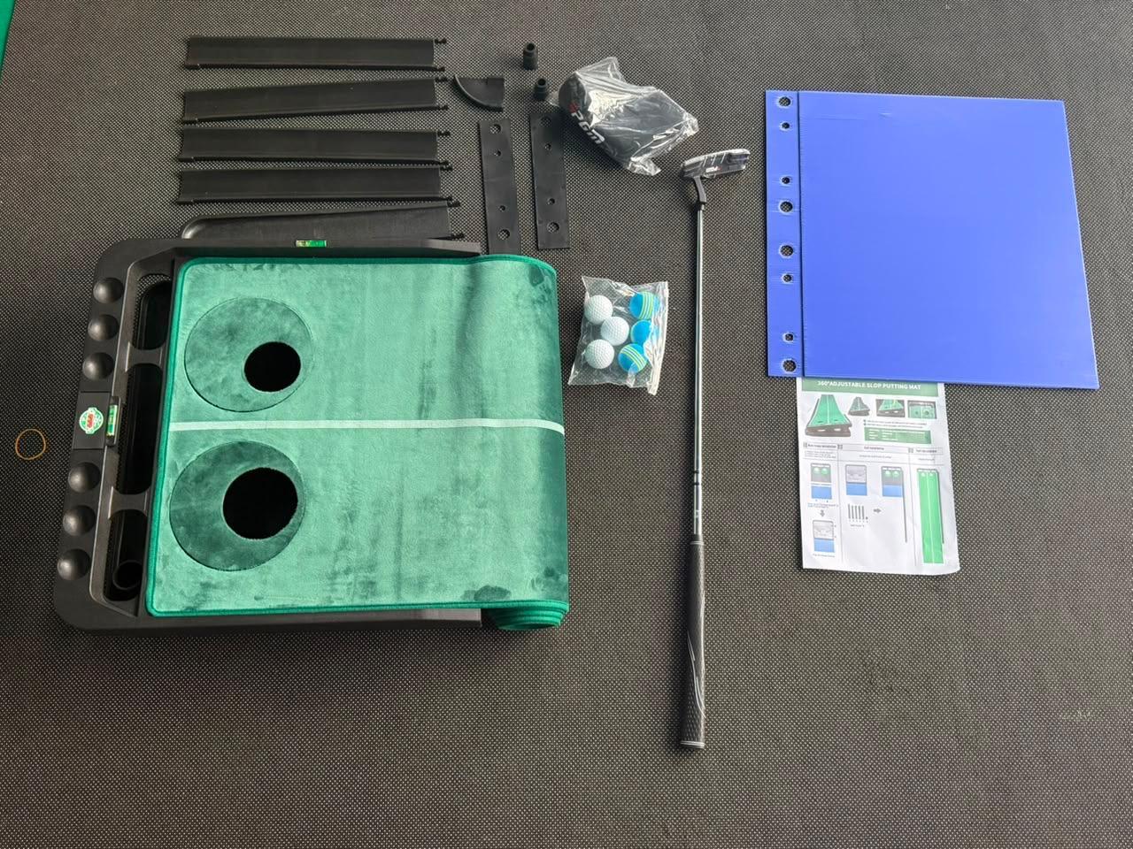 KAAAD GOLF kit contents laid out — mat, base, rails, slope plates, putter, balls and manual